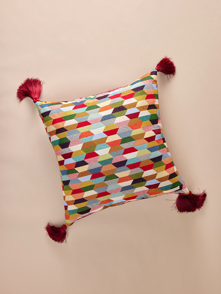Velvet pillowcase with geometric pattern and decorative tassels.