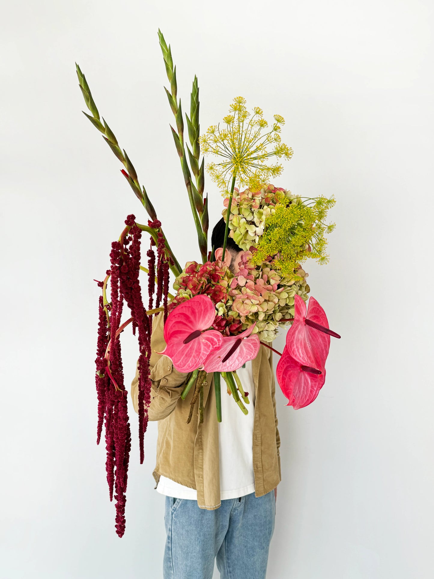 Flower delivery in Dubai: A large bouquet with pink anthuriums, green hydrangeas, yellow dill flowers, red amaranthus, and tall gladiolus stems
