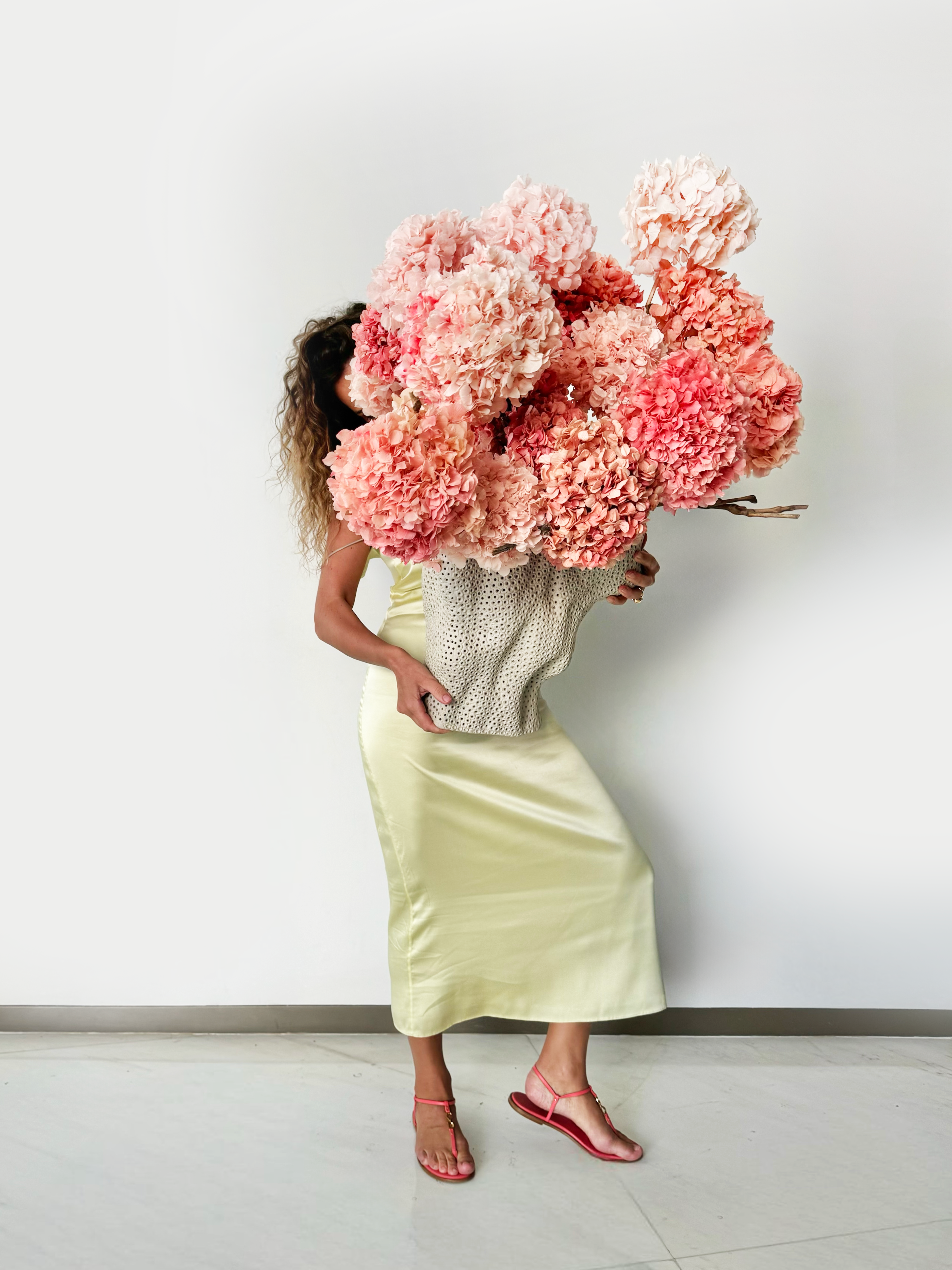 Flower delivery in Dubai: The bloom arrangement in a large, white ceramic vase with a perforated, lattice-like texture