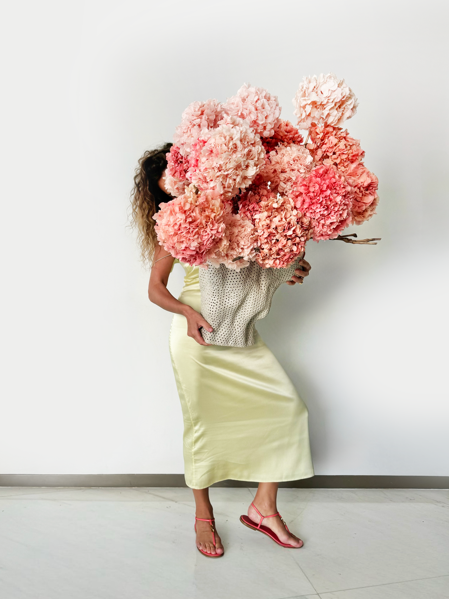 Flower delivery in Dubai: The bloom arrangement in a large, white ceramic vase with a perforated, lattice-like texture
